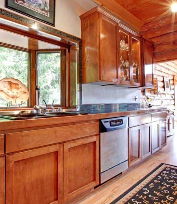 Large kitchen log cabin house interior with wooden cabinets and ceiling