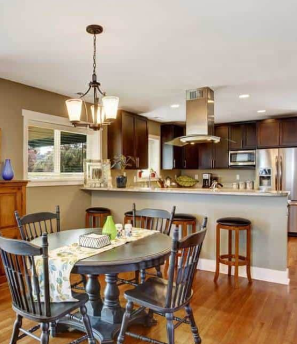 Dark brown kitchen room with round rustic dining table and chairs