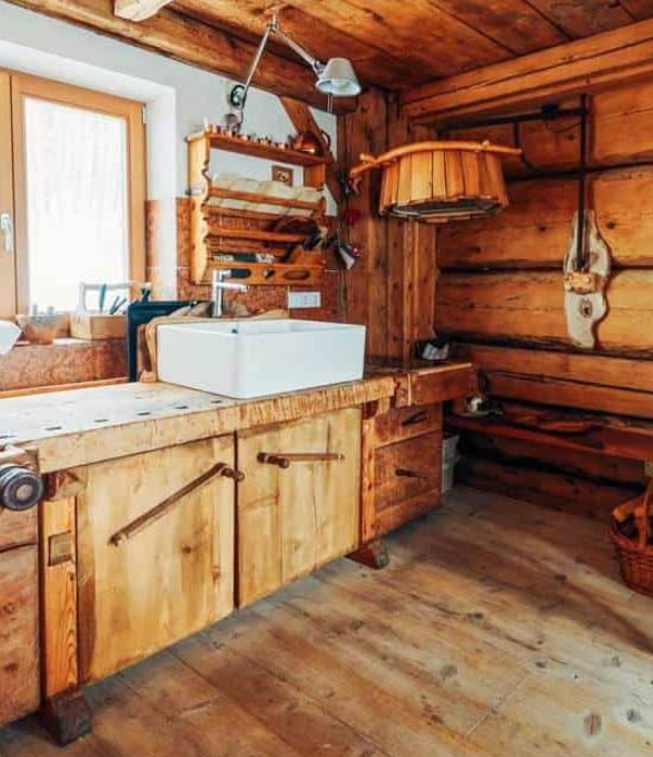 Gorgeous primitive farmhouse kitchen with bold wood cabinets and an iron furnace